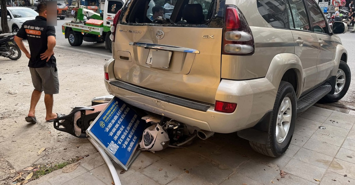 Ô tô Prado lùi trên đường Hà Nội, cuốn xe máy chở 2 phụ nữ vào gầm缩略图